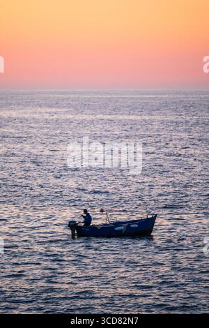 Barca da pesca al tramonto a Polignano a Mare, Puglia, Italia Foto Stock