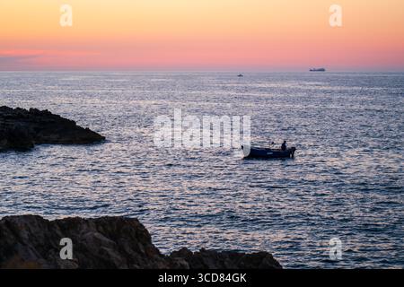 Barca da pesca al tramonto a Polignano a Mare, Puglia, Italia Foto Stock
