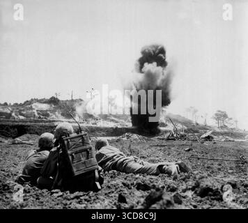 OKINAWA, GIAPPONE - maggio 1945 - Un equipaggio di demolizione della 6a Divisione Marines del corpo dei Marines degli Stati Uniti guarda le cariche di dinamite esplodere e distruggere un Giappone Foto Stock