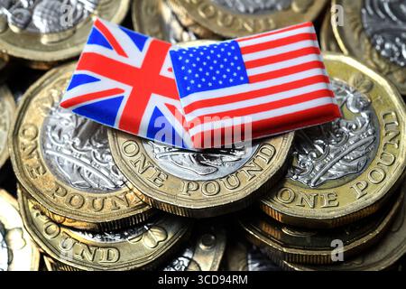LE BANDIERE BRITANNICHE E AMERICANE CON MONETE DA UNA STERLINA RIPAGANO I TASSI DI CAMBIO DELLA STERLINA DEL DOLLARO DELL'ECONOMIA ETC UK Foto Stock