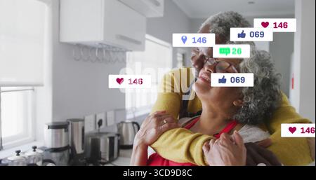 Una coppia che indossa un grembiule rosso, un maglione giallo in cucina, con icone sociali galleggianti, un frullatore Foto Stock