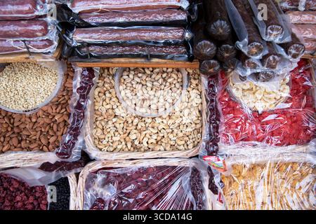 Varietà di frutta secca, noci e dolci tradizionali, tra cui il churchkhela esposto in cesti in un mercato. Solo per uso editoriale. Foto Stock