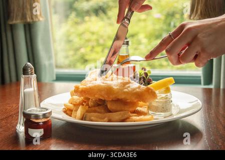 Fish and chips con piselli e salsa di tartaro. Cucina tradizionale inglese. Foto Stock
