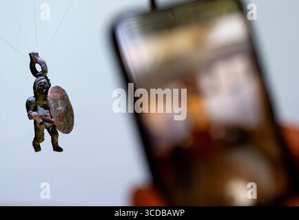 13 agosto 2025, Baviera, Monaco di Baviera: Una statuetta guerriera (guerriero di bronzo - ca. III secolo a.C.) è in mostra durante la presentazione dei reperti provenienti dagli scavi dell'insediamento celtico di Manching presso l'Ufficio di Stato bavarese per la conservazione dei monumenti. Secondo l'Ufficio di Stato, l'oppidum di Manching è l'insediamento celtico meglio studiato nell'Europa centrale. Dal 2021 al 2024, gli archeologi esaminarono il monumento in dettaglio come parte dei lavori di costruzione. I reperti forniscono una visione unica della vita, del lavoro e della morte in un grande insediamento della tarda età del ferro. Foto: Sven Hoppe/dpa credito: d Foto Stock