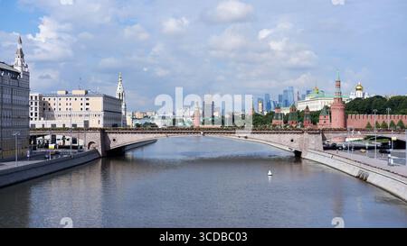 Mosca, Russia - 17 luglio 2025: Vista sul fiume Moskva con Bolshoy Ponte Moskvoretsky e torri del Cremlino sotto le nuvole estive luminose nel centro di Mosca Foto Stock
