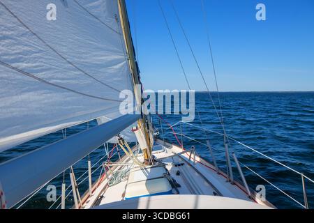 Yacht a vela di lusso sotto genova e vela principale che attraversa le onde del Mar Baltico e del Golfo di Finlandia. Vista dal ponte alla prua, all'albero e alle vele, con i vuoti Foto Stock