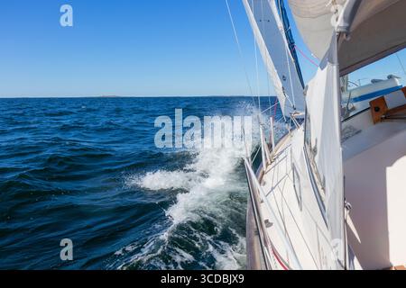 Yacht a vela di lusso sotto genova e vela principale che attraversa le onde del Mar Baltico e del Golfo di Finlandia. Vista dal ponte alla prua, all'albero e alle vele, con i vuoti Foto Stock