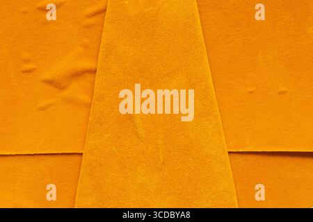 Primo piano di pelle scamosciata arancione con superficie e pieghe irregolari, trama per sfondo o sfondo Foto Stock