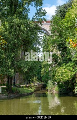 Ponte per l'isola del Belvedere nel Parc des Buttes Chaumont situato nel 19° arrondissement di Parigi Foto Stock