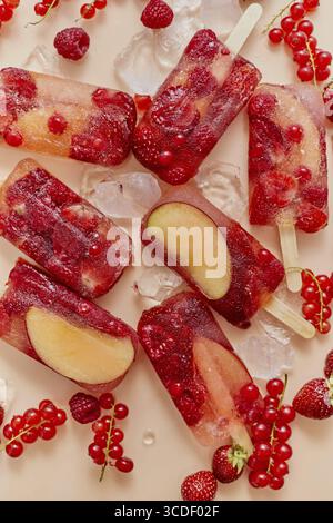 Vari tipi di bacche rosse surgelati fatti in casa, papaveri di succo naturale, paletas, ghiaccioli. Vista dall'alto, orizzontale, verticale. Sano snack estivo Foto Stock