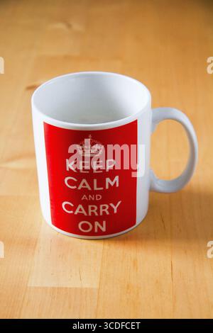 Immagine STILL Life di una tazza di caffè cinese bianca stampata con una corona reale e le comiche parole patriottiche mantengono la calma e continuano. Foto Stock