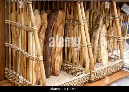 Parigi, Francia. Baguette fresche in cesti presso una boulangerie locale nel mercato alimentare del 18° arrondissement. Foto Stock