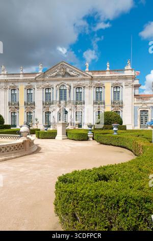 Lisbona, Portogallo. Vista estiva del cortile del Palazzo reale di Queluz, caratterizzato da giardini ben curati, siepi e architettura del XVIII secolo. Foto Stock