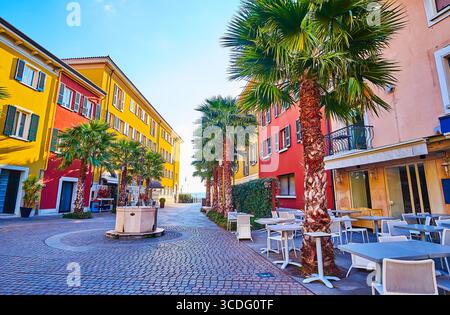 L'antico pozzo Antico Pozzo sulla piazza Castello, fiancheggiata da terrazze di caffè all'aperto, Sirmione, Italia Foto Stock