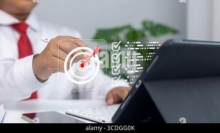 Strategia aziendale, definizione degli obiettivi, obiettivi di marketing e raggiungimento del successo in un ambiente professionale.l'uomo d'affari utilizza lo stilo su schermo digitale W. Foto Stock