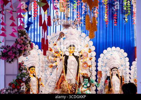 gli idoli della puja indù durga sono esposti in un capannone splendidamente decorato Foto Stock