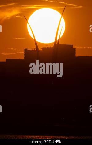 Il sole tramonta dietro l'Air Force Memorial di Arlington, Virginia, 12 agosto 2025. Foto Stock