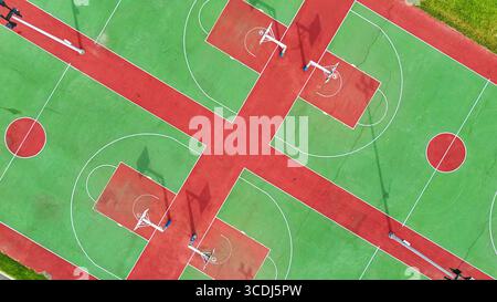 Veduta aerea di numerosi campi da basket all'aperto con marcature rosse e verdi e linee bianche sotto la luce del giorno Foto Stock