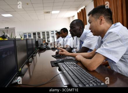 (250813) -- DUBREKA (GUINEA), 13 agosto 2025 (Xinhua) -- tecnici cinesi e guineani lavorano insieme nella sala di controllo della centrale idroelettrica Kaleta di Dubreka, Guinea, il 24 aprile 2025. Sul fiume Konkoure che scorre giù dagli altopiani di Fouta Djallon nella Guinea centrale, l'impressionante struttura della centrale idroelettrica di Kaleta si riflette nelle acque. La struttura ha fornito elettricità stabile alla capitale nazionale di Conakry e ai villaggi delle montagne settentrionali, ora presenti sulla banconota da 000 franchi della Guinea, che mostra un netto contrasto con la scena dieci anni fa. Il 2 agosto Foto Stock