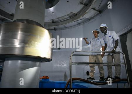 (250813) -- DUBREKA (GUINEA), 13 agosto 2025 (Xinhua) -- tecnici cinesi e guineani ispezionano le attrezzature presso la centrale idroelettrica Kaleta di Dubreka, Guinea, il 24 aprile 2025. Sul fiume Konkoure che scorre giù dagli altopiani di Fouta Djallon nella Guinea centrale, l'impressionante struttura della centrale idroelettrica di Kaleta si riflette nelle acque. La struttura ha fornito elettricità stabile alla capitale nazionale di Conakry e ai villaggi delle montagne settentrionali, ora presenti sulla banconota da 000 franchi della Guinea, che mostra un netto contrasto con la scena dieci anni fa. Nell'agosto 2015, la Kaleta Foto Stock