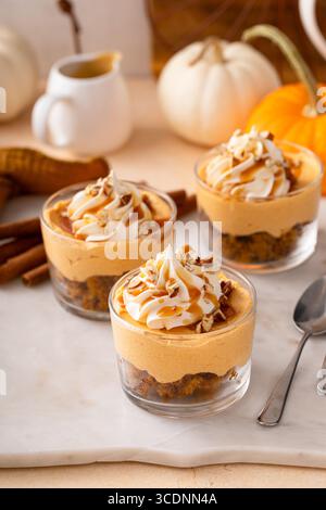 Cheesecake di zucca in un bicchiere con panna montata e noci pecan, idea di dessert autunnali, niente dolci al forno per il giorno del Ringraziamento Foto Stock