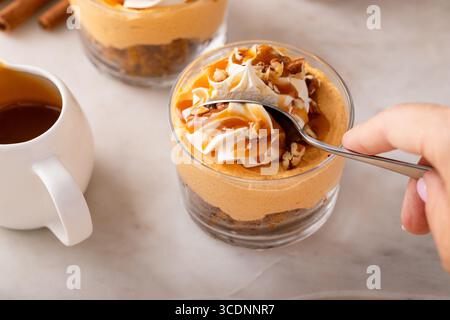 Cheesecake di zucca in un bicchiere con panna montata e noci pecan, idea di dessert autunnali, niente forno dessert del giorno del Ringraziamento, prendere un boccone Foto Stock