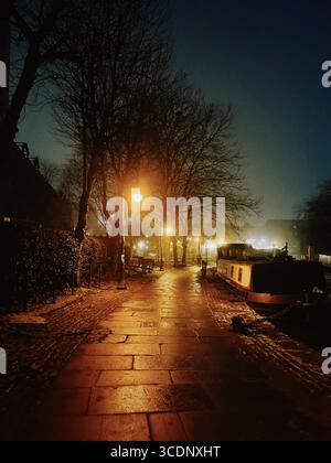 Castlefield Canal a Manchester di notte, con chiatte illuminate e riflessi nell'acqua Foto Stock