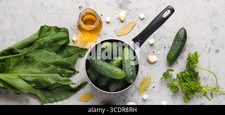 Composizione con cetrioli freschi e ingredienti da conservare su fondo grigio Foto Stock