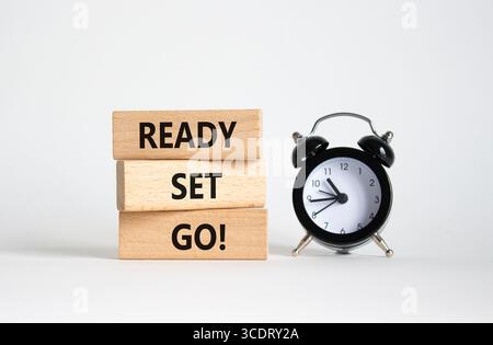 Simbolo pronto per l'avvio. Parole concettuali Ready Set vanno su blocchi di legno. Splendido sfondo bianco con sveglia. Concetto Business e Ready Set Go. Copia Foto Stock