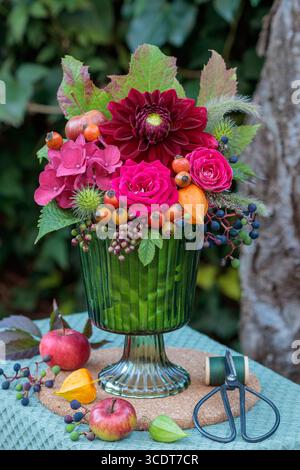 composizione floreale di rose rosse, ortensie in fiore, dahlia e rosa anche in un vaso di vetro Foto Stock