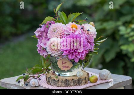 composizione floreale di dalie, ortensie in fiore e virginia creeper in un bicchiere Foto Stock
