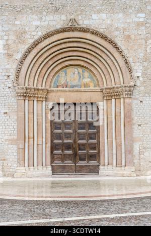 Paesaggio urbano con ingresso laterale della chiesa di Santa Maria di Collemaggio, girato alla luce dell'estate a l'Aquila, Abruzzo, Italia Foto Stock