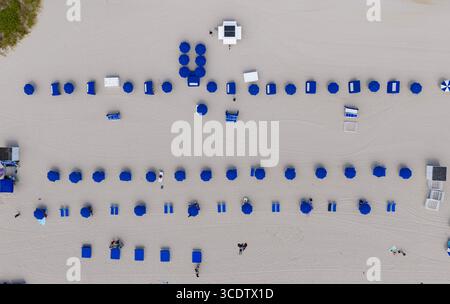 Vacanze estive. Vacanze al mare in estate. Relax al mare sotto l'ombrellone. Viaggia verso il mare. Vista dall'alto della spiaggia di sabbia con acqua turchese. L Foto Stock