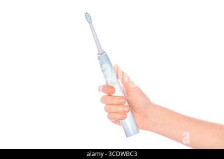 Spazzolino elettrico in mano isolato su sfondo bianco. Donna che tiene in mano uno spazzolino elettrico, primo piano. Spazzolino elettrico intelligente. Tecnologia moderna per Foto Stock