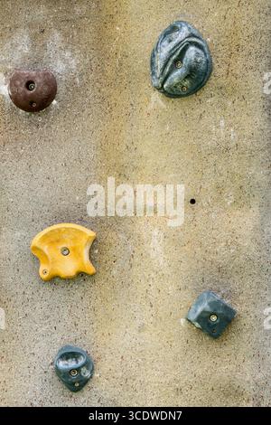 Vista ravvicinata delle colorate strutture per arrampicata su una parete di roccia artificiale. Foto Stock