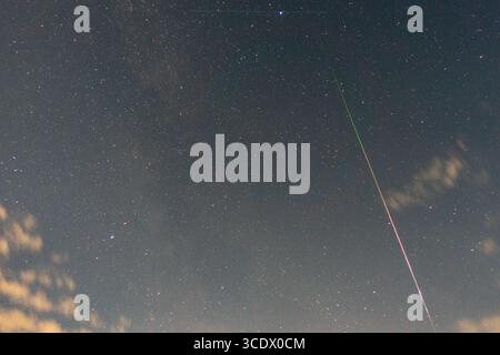 Ripon, North Yorkshire, Regno Unito. 13 agosto 2025. Sentiero meteorologico catturato al picco della pioggia di meteoriti dei Perseidi. La pioggia di meteoriti dei Perseidi è un evento annuale in cui è possibile vedere molte "stelle cadenti" nel cielo notturno. Succede intorno a metà agosto quando la Terra passa attraverso una scia di polvere e detriti lasciati da una cometa chiamata Swift-Tuttle. Quando questi piccoli frammenti di polvere di comete colpiscono l'atmosfera terrestre, si bruciano creando delle strisce luminose. Puoi vedere i Perseidi meglio nell'emisfero settentrionale, specialmente nei cieli bui e limpidi lontano dalle luci della città. La doccia prende il nome dalla costellazione Foto Stock