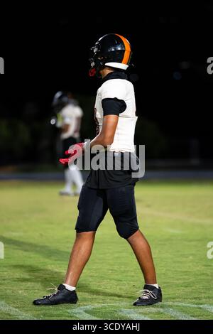 Il wide receiver focalizzato sul football americano è pronto, il quarterback è bloccato dagli occhi, vestito di bianco, nero e arancione, pronto per lo snap Foto Stock