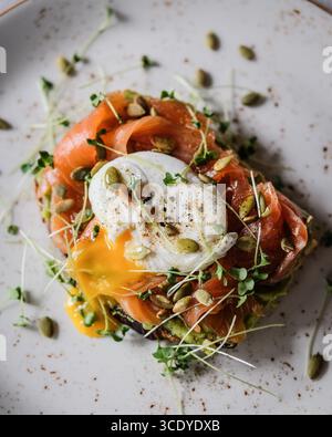Una colazione elegante e deliziosa con salmone affumicato abbinato a un uovo in camicia Foto Stock