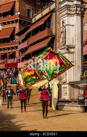 La comparsa del Drago Contrada si esibisce durante il Corteo storico in Piazza del campo, il Palio, Siena, Italia. Foto Stock