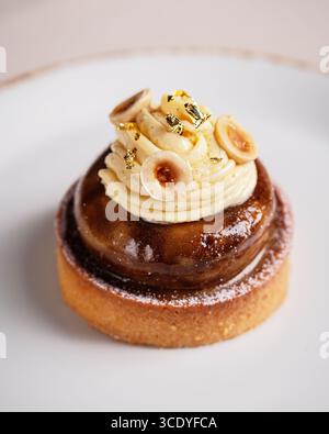 Viziatevi con un delizioso dessert Gourmet caratterizzato da una ricca crema di nocciole completata da una deliziosa glassa Foto Stock