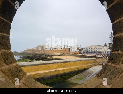 Guardando le vecchie mura della città di Essaouira attraverso un buco nei bastioni Foto Stock
