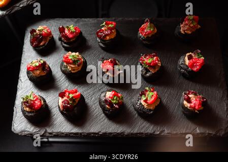 Una selezione di antipasti gourmet disposti elegantemente su un piatto di ardesia. questa esposizione culinaria presenta una varietà di ingredienti colorati, che offrono un Foto Stock