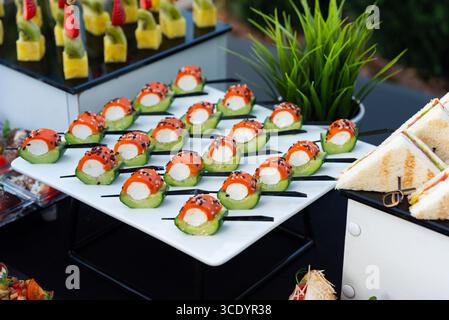 Una presentazione di sushi splendidamente organizzata con rotoli vivaci su un elegante piatto bianco. ideale per matrimoni, riunioni aziendali o feste di lusso Foto Stock
