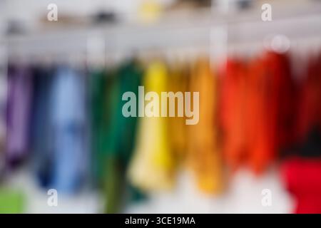Vista sfocata dei vestiti colorati appesi nella boutique Foto Stock
