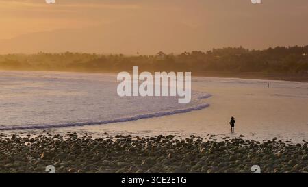 una foto al tramonto di un pescatore dalla silhouette che pesca al medewi sull'isola di bali, indonesia Foto Stock