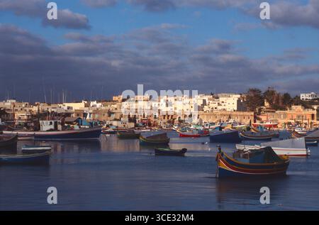 Malta. Marsaxlokk. Edifici sul lungomare e porto. Foto Stock