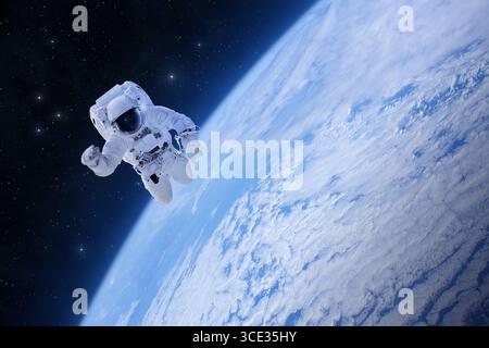 Spaceman in tuta spaziale nello spazio sopra la Terra. Passeggiata spaziale dell'astronauta. Cosmonauta che galleggia nello spazio. Elementi di questa immagine forniti dalla NASA. Foto Stock