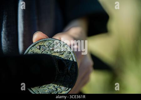 Un samurai in kimono nero sta camminando attraverso la foresta. Foto Stock
