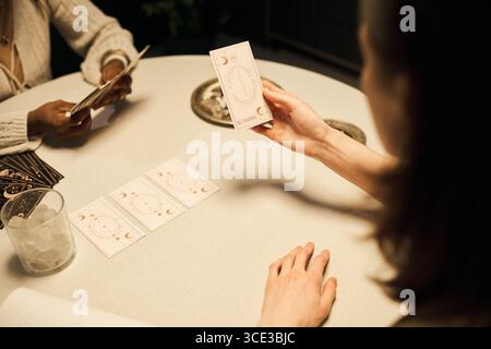 Giovani donne adulte di diverse etnie che leggono le carte dei Tarocchi insieme Foto Stock
