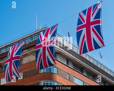 Tre bandiere di bandiera britannica del Regno Unito di fila contro il cielo blu Foto Stock